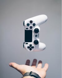 An individual raises a white video game controller in celebration.